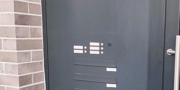 Klingel- und Briefkastenanlage in der Haustuer eines Mehrfamilienhauses
