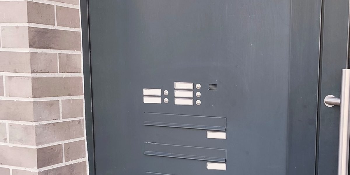 Klingel- und Sprechanlage mit Briefkästen in der Haustür eines Mehrfamilienhauses